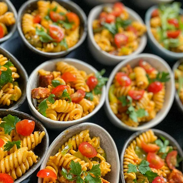 Pastasalade met tomaat in individuele potjes voor crewcatering