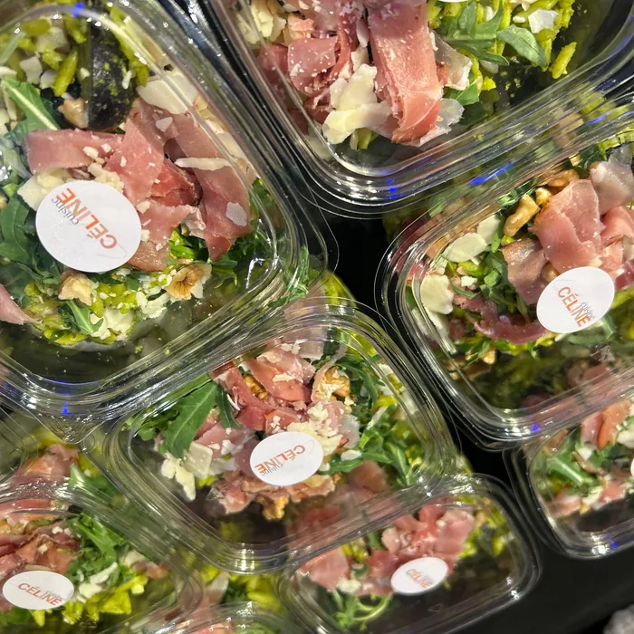 Verse salades met ham in aparte lunchbakjes voor een productieploeg