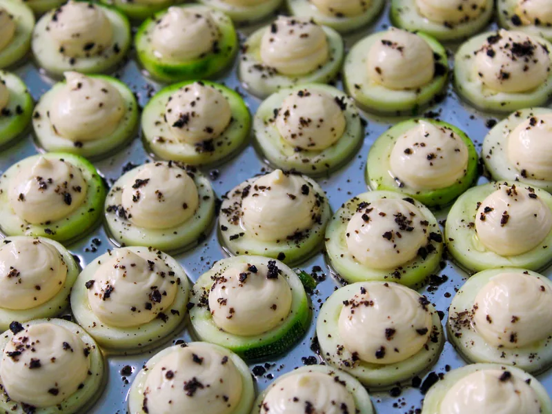 Komkommerhapjes met mousse en zwarte olijfcrumble voor een walking dinner